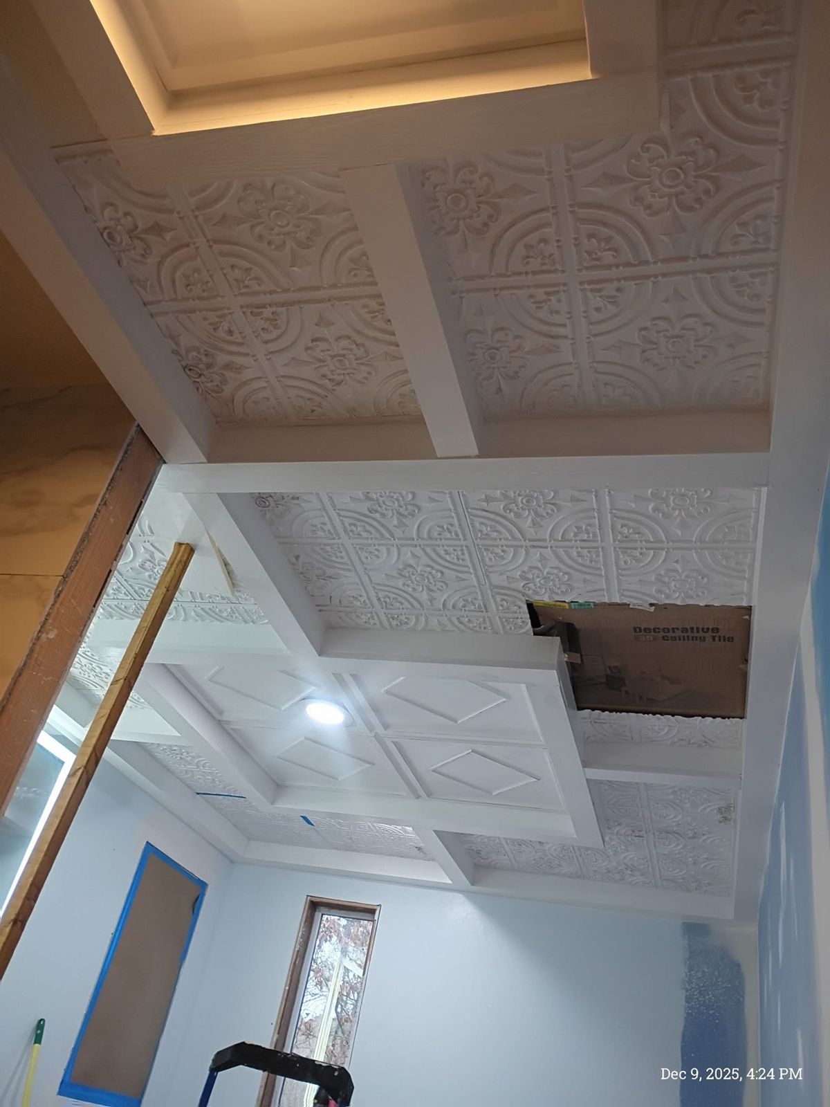 Coffered bathroom ceiling with white beams and decorative pressed-pattern ceiling tiles
