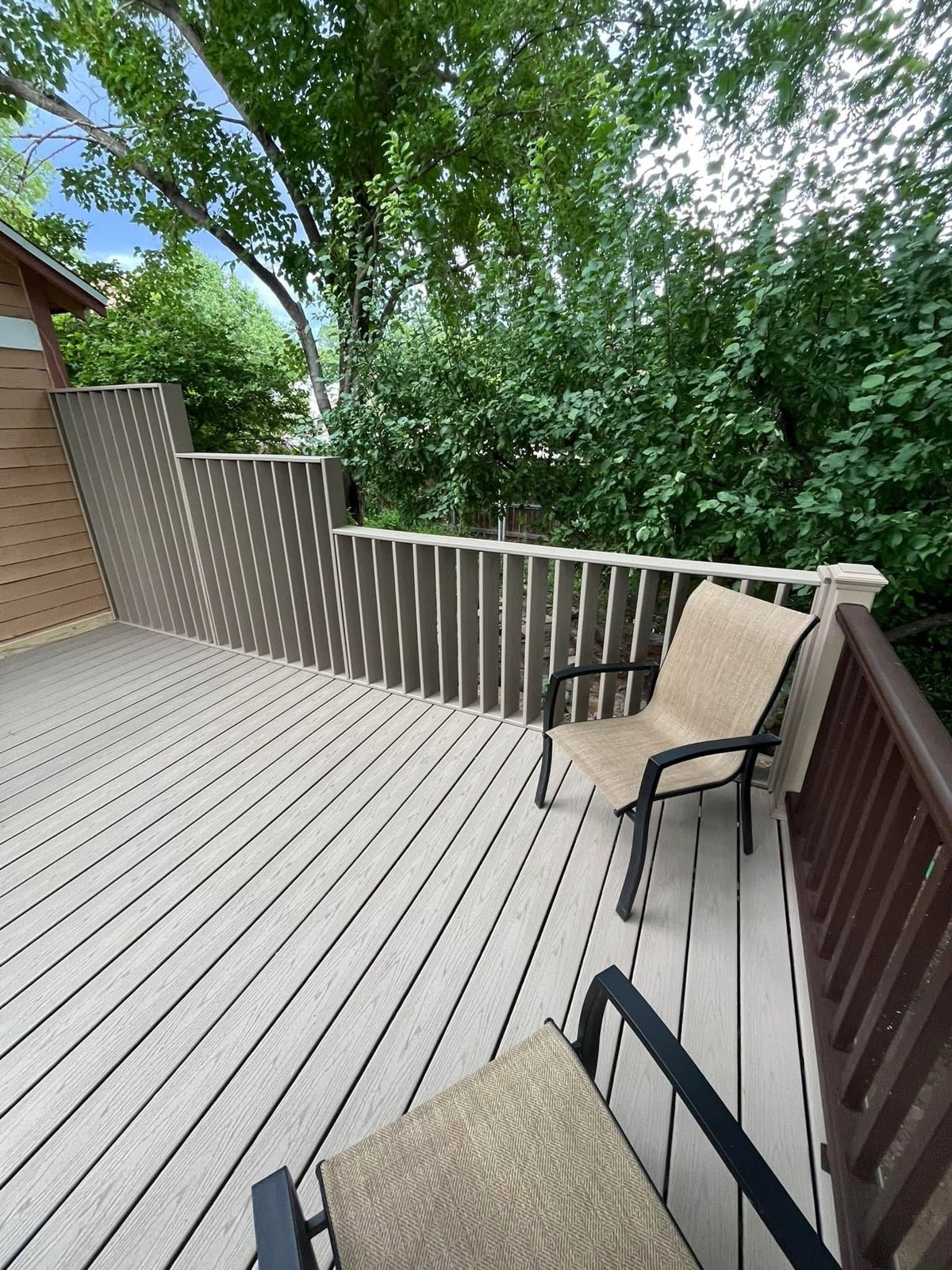 Composite deck boards with a stepped privacy railing along one side