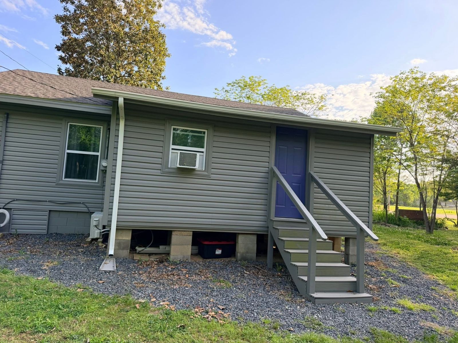 New white gutter and downspout on gray vinyl siding