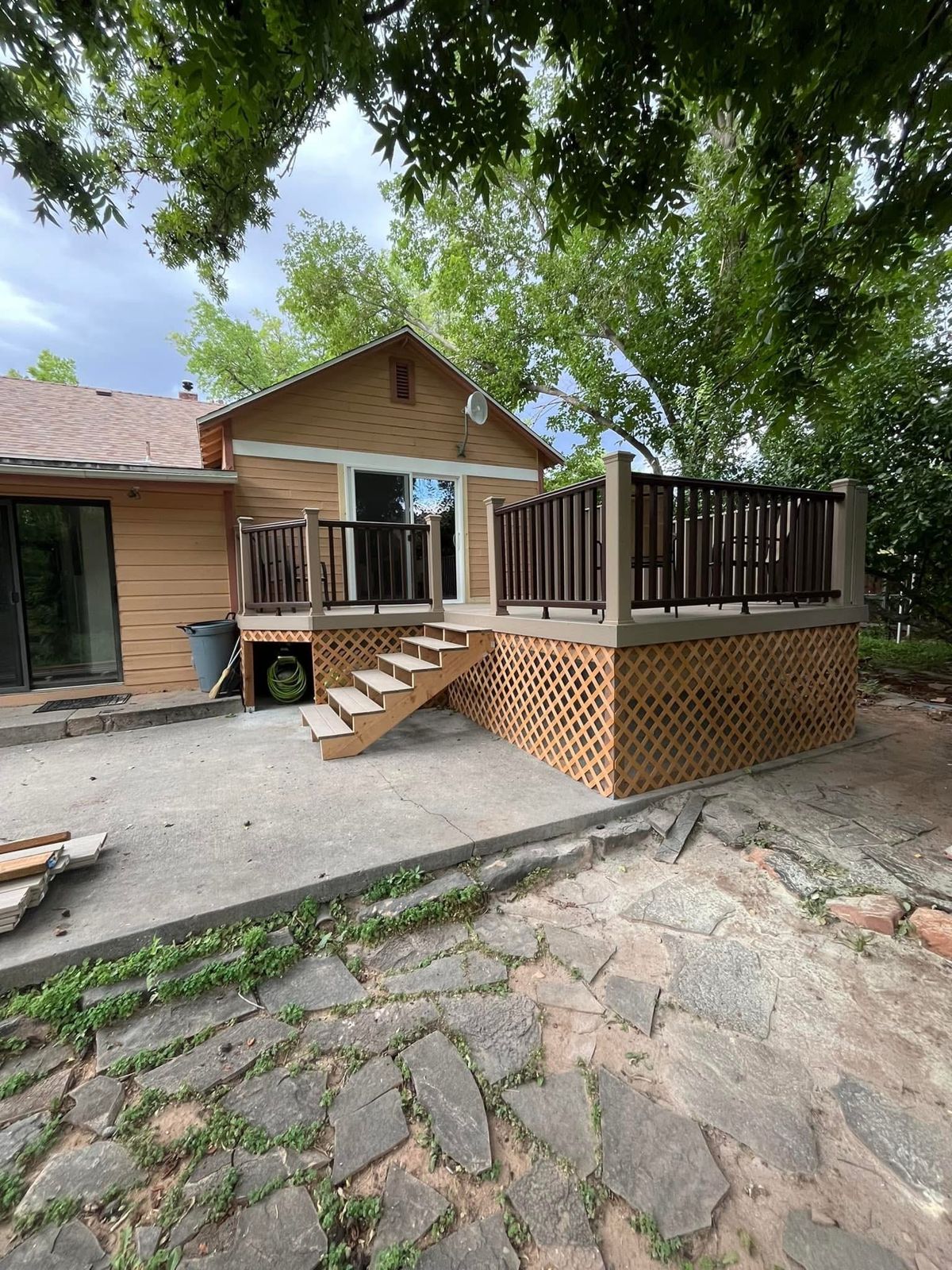 Raised composite deck with railings and stairs that we built