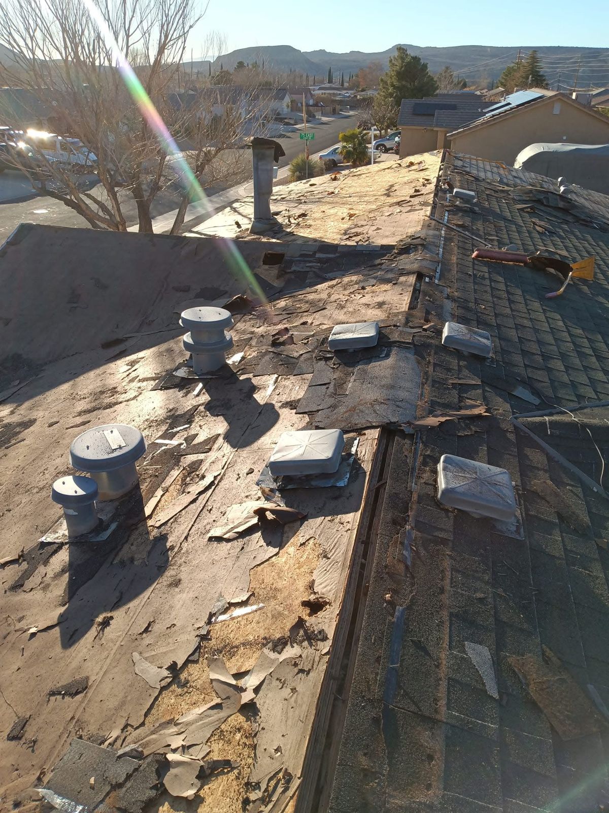 Before: old shingles torn off down to the roof deck, with worn underlayment and exposed vents